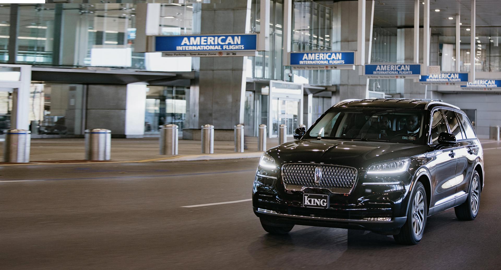 Black car driving by the airport