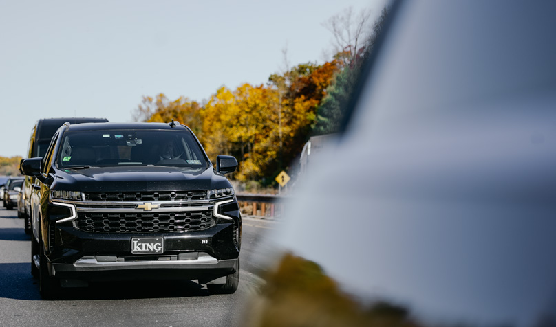 SUV driving on a road in the fall