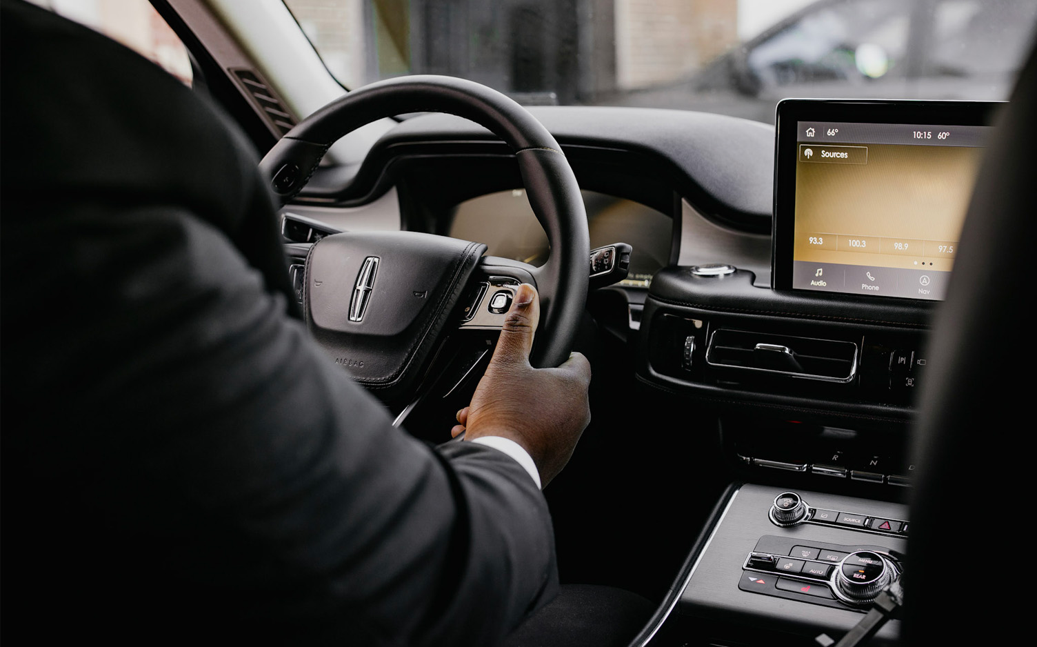 driver holding steering wheel in a luxury car